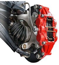 Load image into Gallery viewer, A front corner assembly of a UTV with a red Wilwood caliper installed
