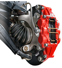 Load image into Gallery viewer, A front corner assembly of a UTV with a red Wilwood caliper installed