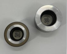 Load image into Gallery viewer, Top-down picture of two brake caliper pistons showing a two digit number embossed in the base of the pistons.
