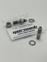 Load image into Gallery viewer, Two titanium studs, nuts, and washers on a white background with packaging in the background