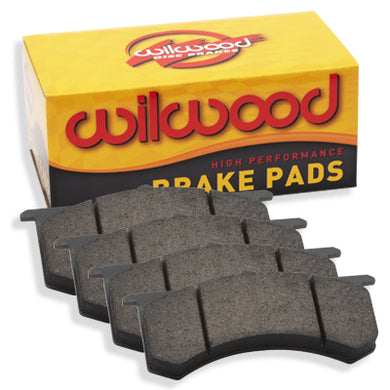 A yellow Wilwood brake pad box with 4 brake pads set in front of it
